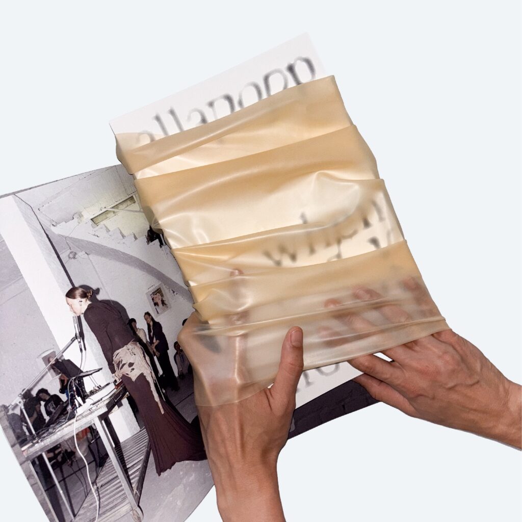 Aufgeschlagenes Magazin in einer Hülle aus hautfarbenem Latex